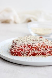 a piece of seared ahi tuna with sesame seeds on a plate.