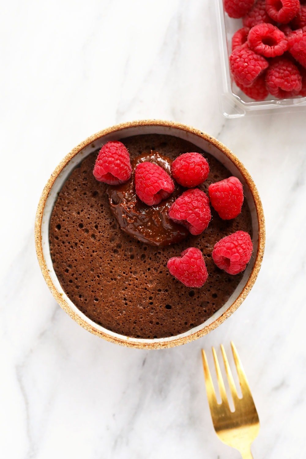 Dessert is served in 7 minutes! Make this single-serve chocolate mug cake with an easy chocolate frosting for a delicious sweet treat today. single-serve chocolate mug cake topped with fresh raspberries and homemade chocolate frosting