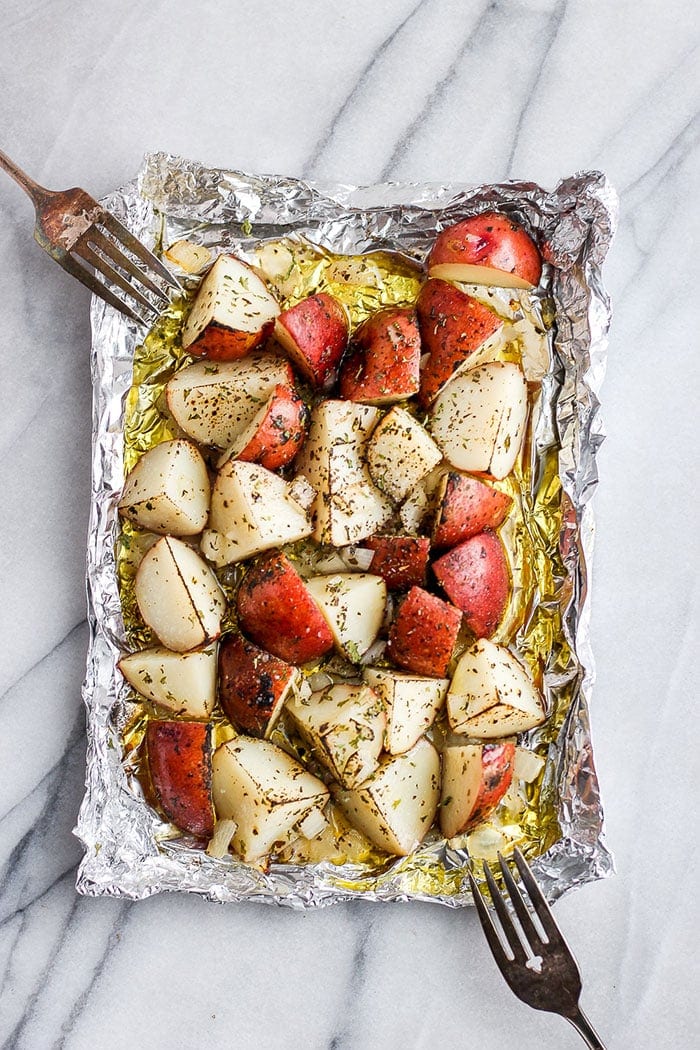 Get perfectly cooked potatoes every time with this grilled potatoes in foil method. They're made with grilled red potatoes, olive oil, and your favorite spices. grilled potatoes on a piece of foil