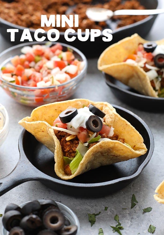 Taco night just got a whole lot cuter! Get the whole family involved and make these adorable mini taco cups made with homemade hard shell taco boats. Mini taco cups on a plate.