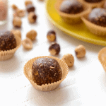 Chocolate hazelnut truffles on a yellow plate.