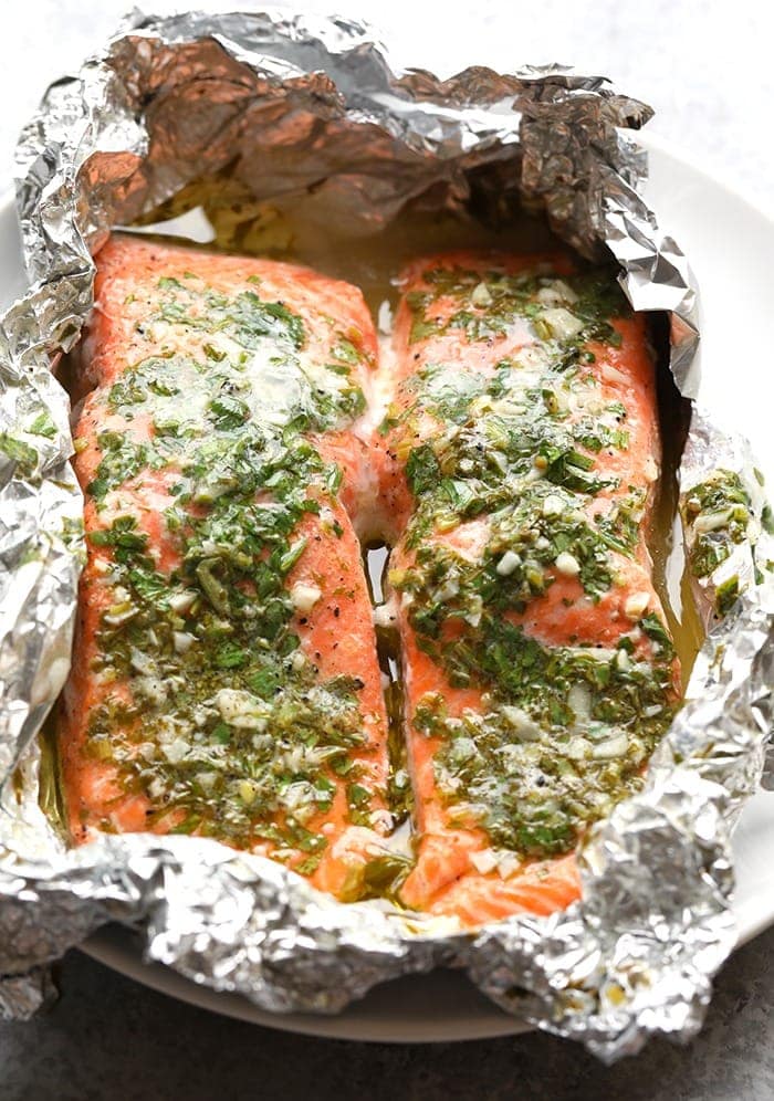 This grilled salmon in foil recipe is flakey and tender made with a simple herby butter for a fresh and healthy meal ready in under 30! salmon with herbs in foil.