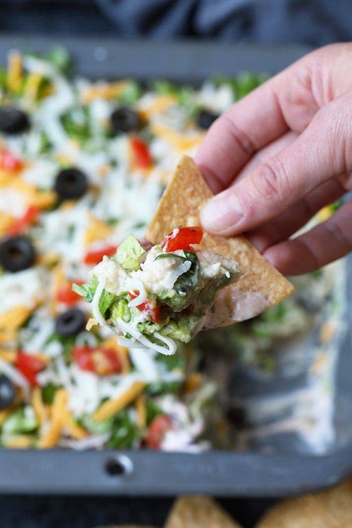 healthy taco dip on a chip ready to be eaten