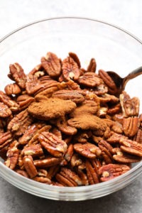 Roasted pecans in a glass bowl.