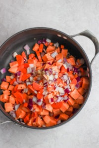 Cooked carrots and onions in a pan for curry chicken soup.