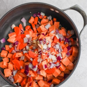Cooked carrots and onions in a pan for curry chicken soup.
