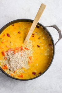 A steaming bowl of curry chicken soup with a wooden spoon in it.
