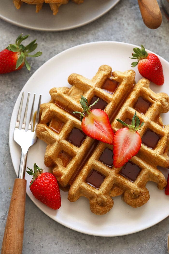 Finally protein waffles that are fluffy and delicious! Get a whopping 12g of protein from these healthy Protein Waffles made with 100% whole grains and no added sugar. Breakfast is served! healthy protein waffles on a plate