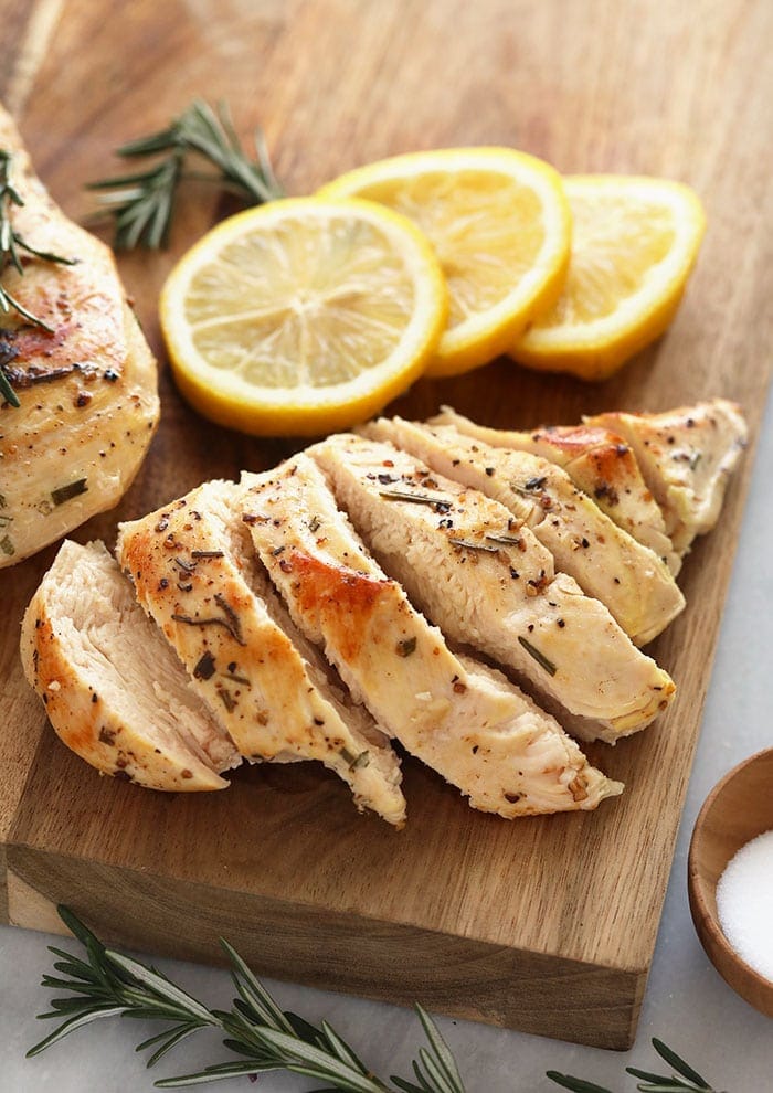 The sous vide is the newest hotness in the kitchen and guess what? Team Fit Foodie has totally bought into the perfectly cooked protein goodness that the sous vide produces. If you have a sous vide you know how easy it is to prepare food ahead of time that you know will turn out just the way you want it. Today we are chatting about sous vide chicken breast and sharing some of the best sous vide chicken recipes on the internet! chicken breast on a cutting board.