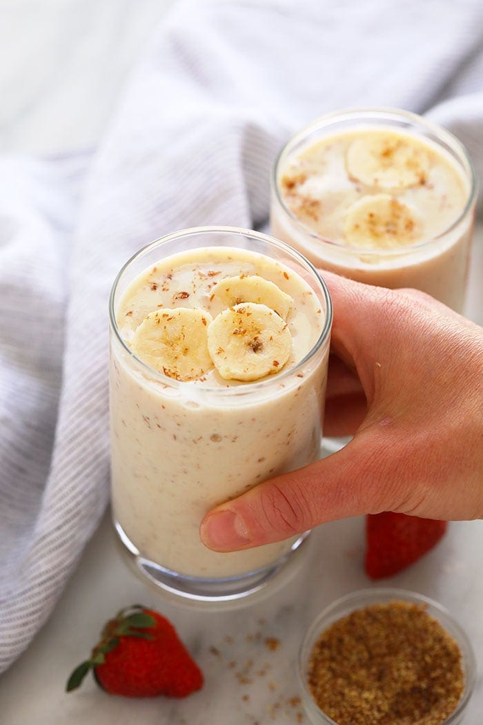 Let me introduce you to the creamiest and most delicious banana smoothie. This healthy banana smoothie is simple and packed with protein, fiber, and potassium! Blend it up this week for a healthy banana smoothie breakfast! A hand holding a banana smoothie