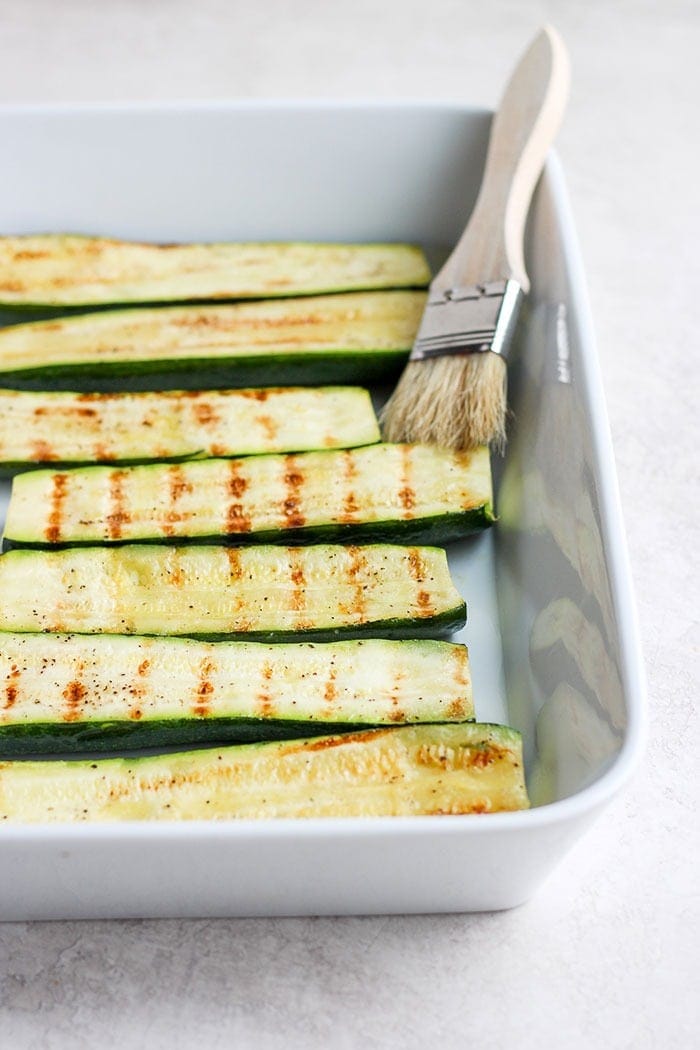 Turn on the grill and throw on some zucchini! Making grilled zucchini is easy and if you do it right you'll end up with grilled zucchini with a little crunch rather than a soggy mess. Grab the zucchini from your garden or the grocery store and get grilling! grilled zucchini in a baking dish.