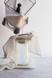 sieving oat milk.