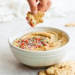 A bowl of peanut butter hummus topped with sprinkles.