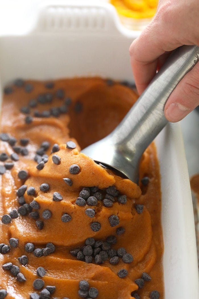 Nice cream made to taste like pumpkin pie? Heck yes! Made in less than 5 minutes, this vegan frozen treat tastes just like fall! scooping nice cream out of container