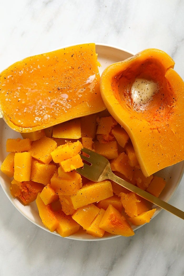 Cook butternut squash in no time by cooking it in the Instant Pot! You will have perfectly cooked butternut squash in under 10 minutes. Use the butternut squash in all your favorite recipes! cooked butternut squash on a plate with butter, salt, and pepper