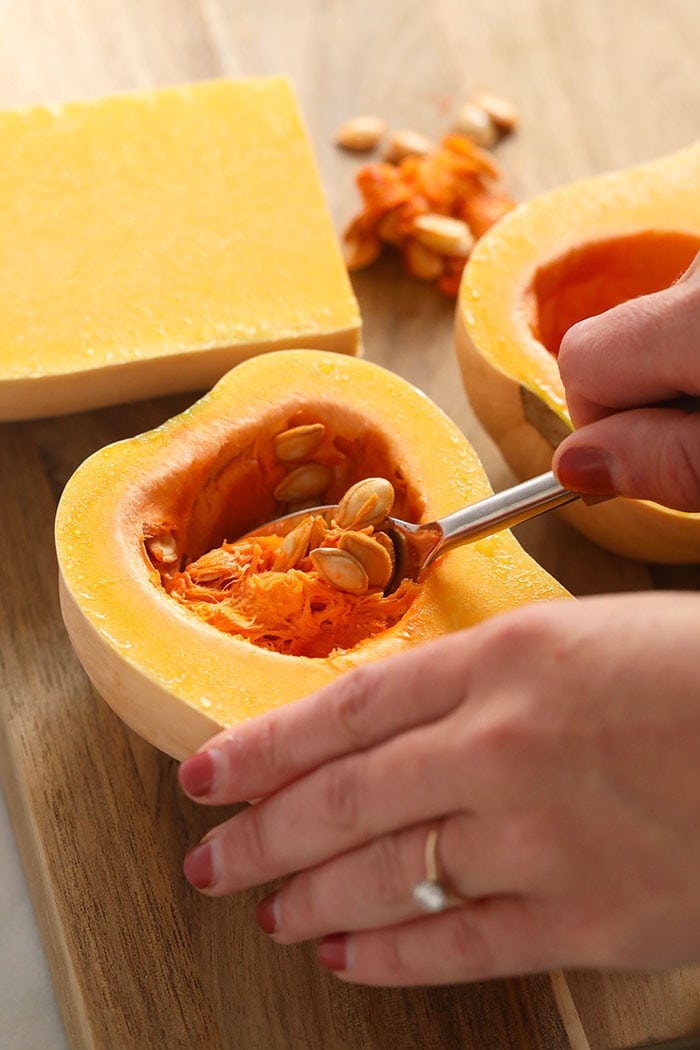 scooping out the seeds from a butternut squash