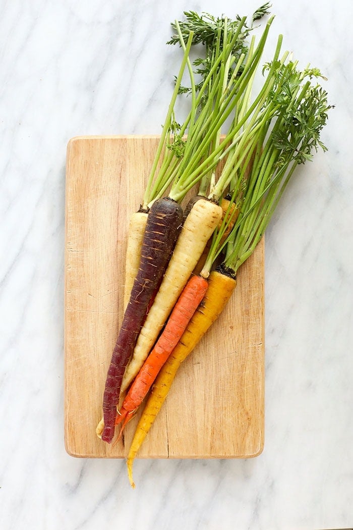 multi-colored carrots on a cutting board