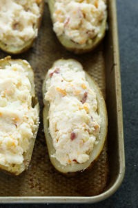 Four twice baked potatoes on a baking sheet.
