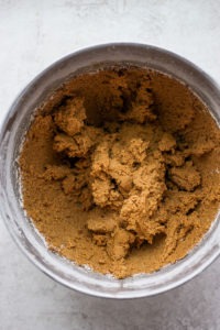 A metal bowl of brown sugar, perfect for making gingersnap cookies.