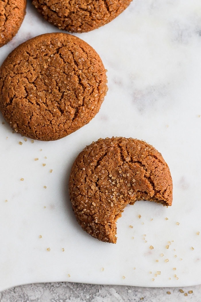 Gorgeous ginger cookies with a crinkly outside and soft and chewy inside. These are the best gingersnap cookies you'll ever eat! ginger cookie with bite taken out of it