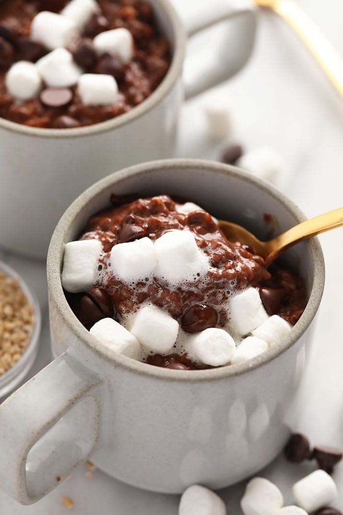 These Hot Cocoa Steel Cut Oats made completely in the slow cooker are truly the most perfect winter breakfast! All the things you love about hot cocoa rolled up into a nutritious breakfast. Enjoy! hot cocoa steel cut oats in a mug topped with marshmallows