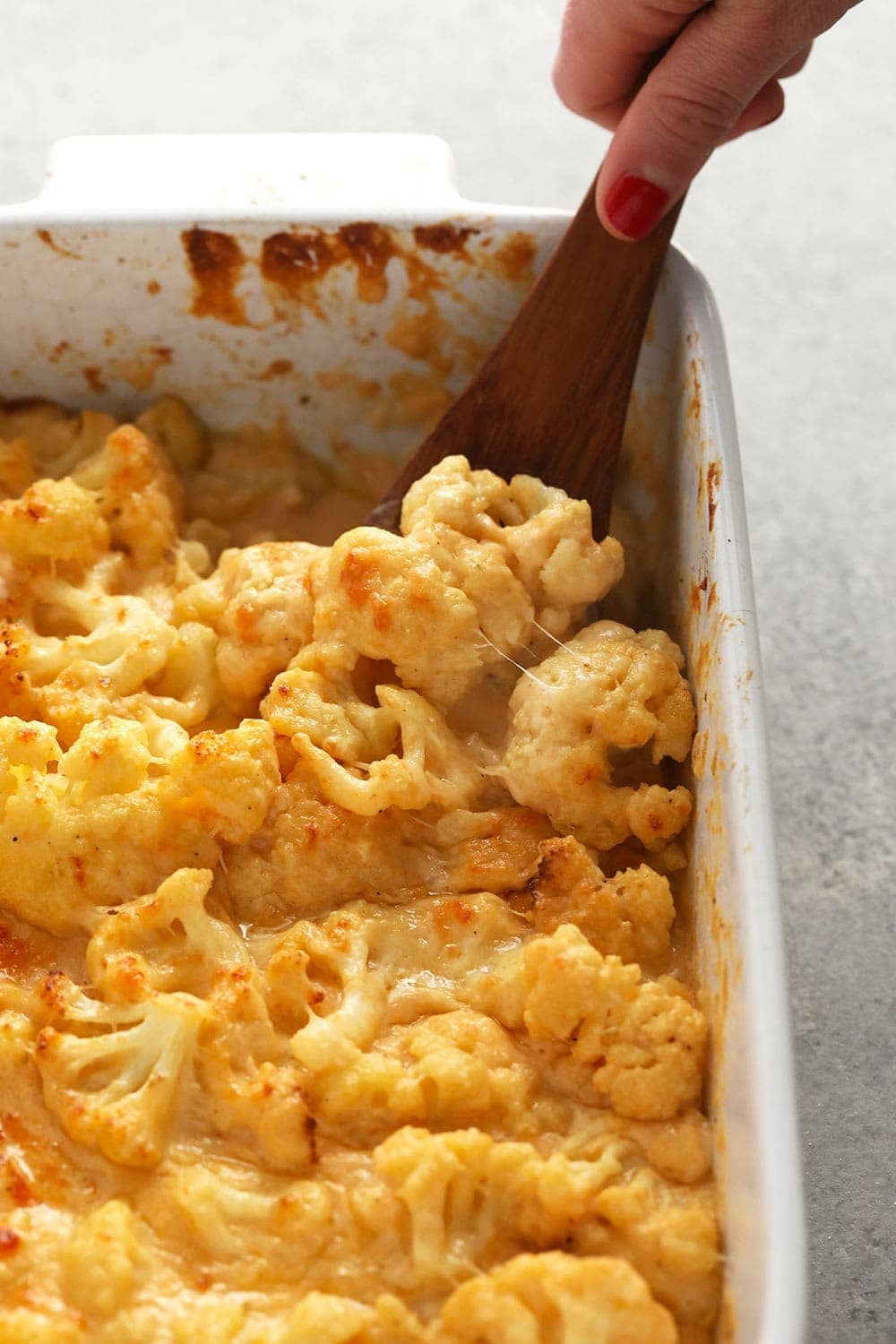 This Three Cheese Cauliflower Mac and Cheese is keto, low carb, and oh so delicious! And did we mention it packs 20g of protein? Yah welcome. cauliflower mac and cheese in a casserole dish
