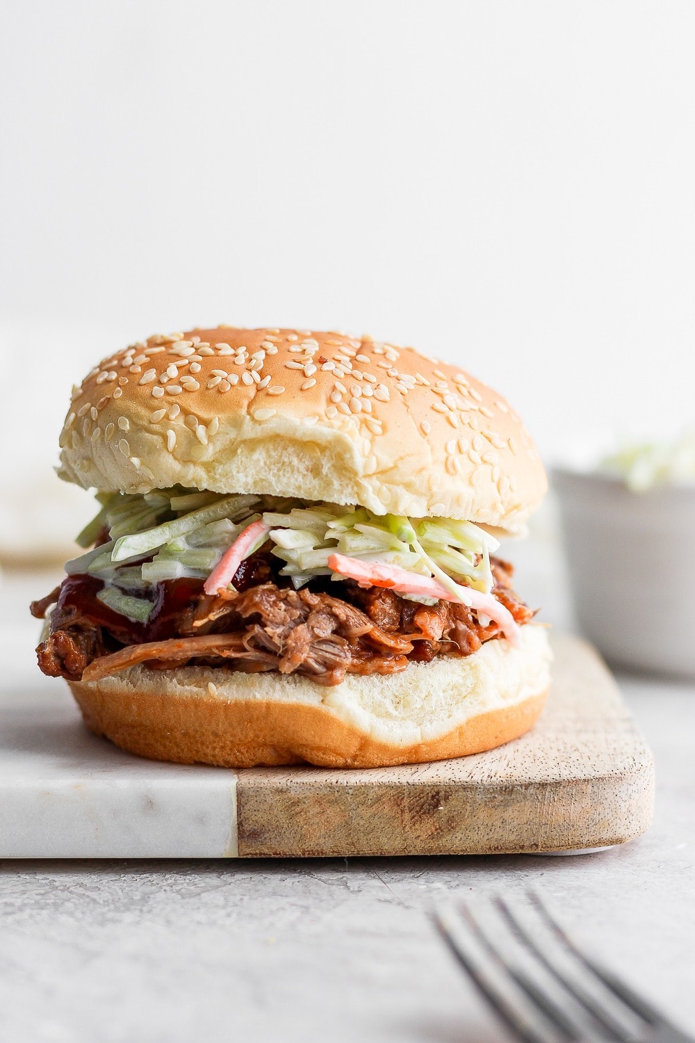 The most tender and juicy Instant Pot Pulled Pork made with a delicious dry rub and your favorite bbq sauce! pulled born on bun with slaw.