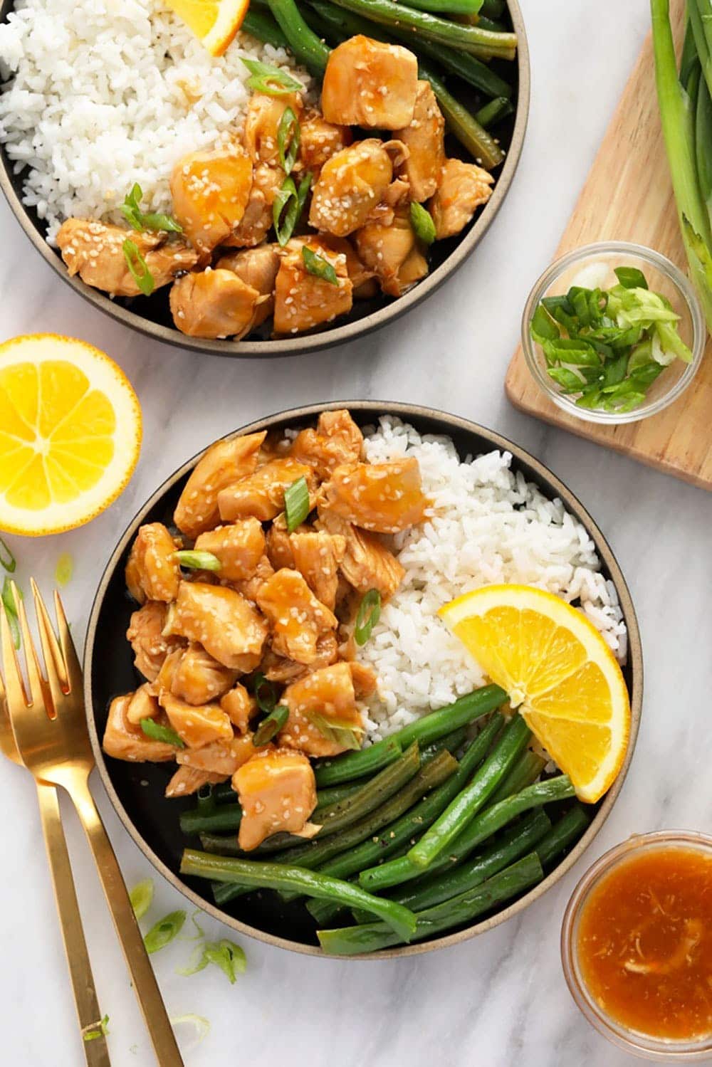 This Instant Pot Orange Chicken is saucy, flavorful, and so easy to make! All you need is your Instant Pot and the ingredients and you will have delicious take-out-tasting orange chicken in less than 30 minutes! orange chicken on a plate with rice and beans