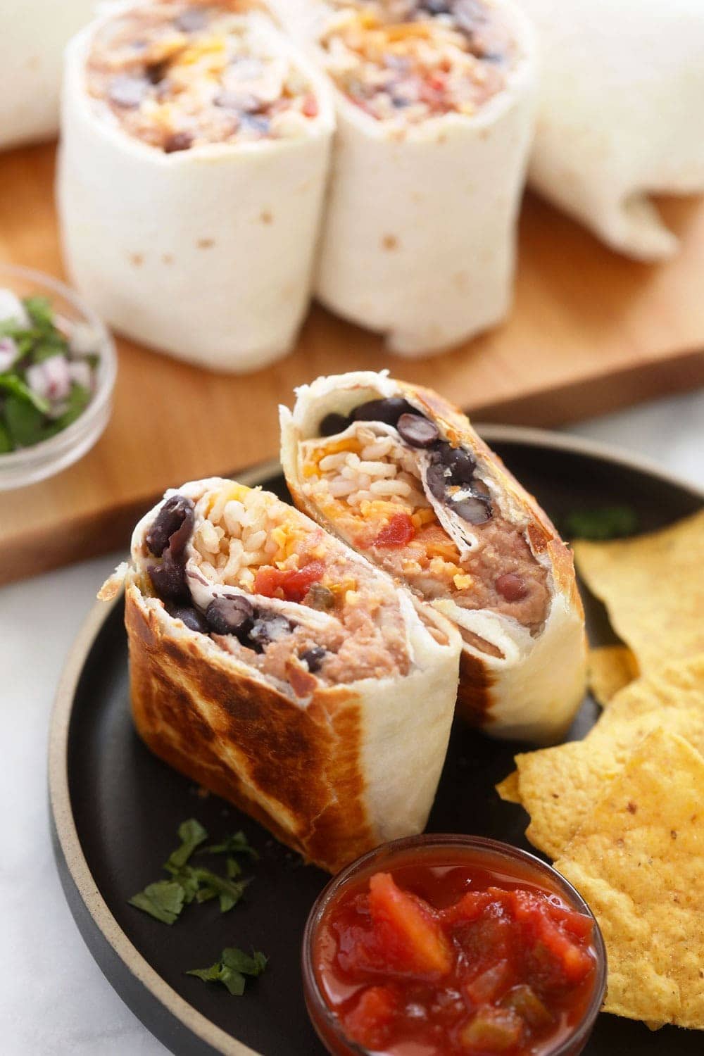 bean burrito on plate with chips Make-ahead bean burritos that use only 6 pantry staple ingredients. You will adore this bean and cheese burrito recipe at work, home, or on-the-go!