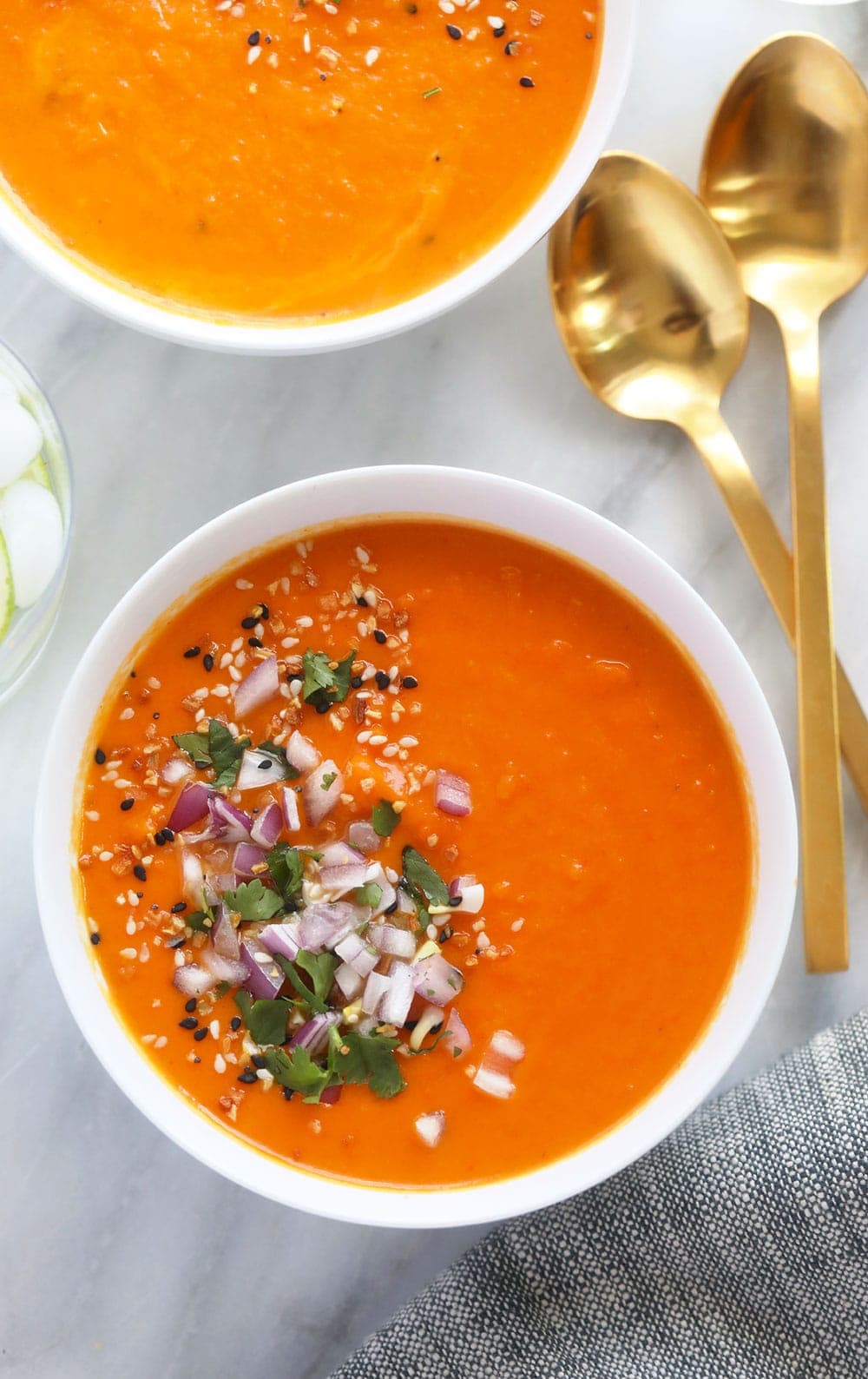 Beautiful Instant Pot Sweet Potato Carrot Ginger Soup made in under 30 minutes with fresh ginger, coconut milk, and red curry paste. instant pot sweet potato carrot ginger soup in a bowl topped with diced onion