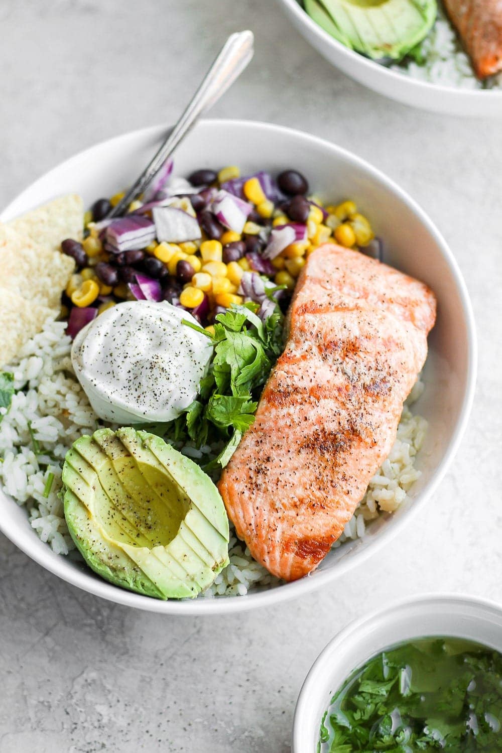 completed fiesta salmon rice bowl with a dollop of sour cream and tortilla chips 