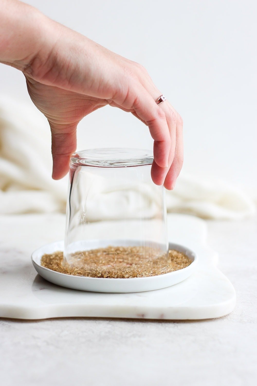 Placing sugar on the rim of a cocktail glass. 
