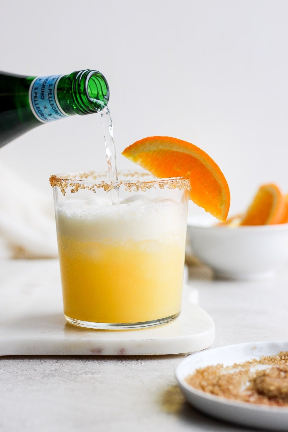Pouring bubbly water into the cocktail. 