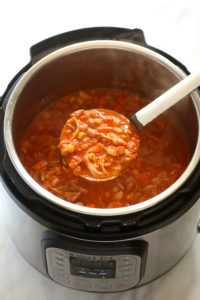 An Instant Pot full of buffalo chicken chili with a spoon in it.