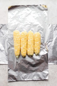 Grilled corn wrapped in foil.