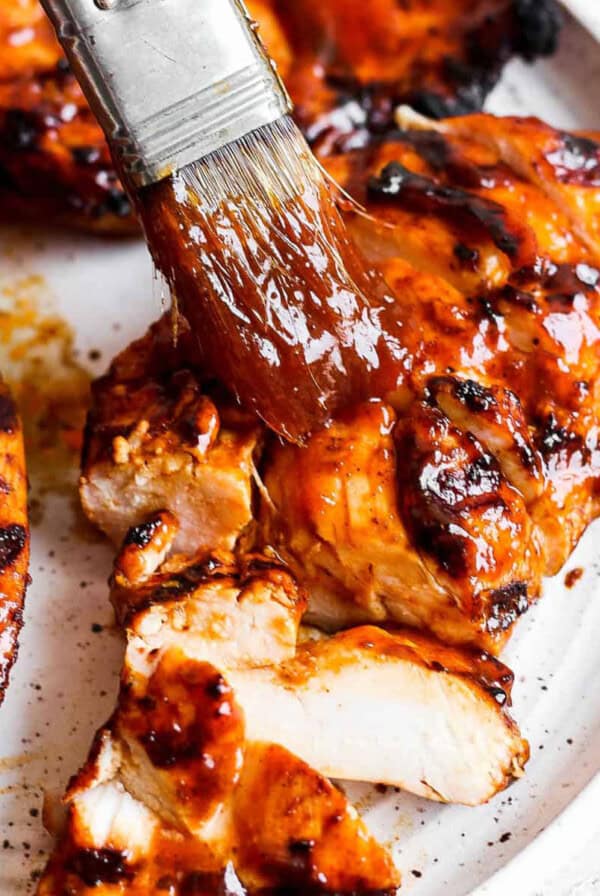 BBQ kyllingbryst blir marinert i en BBQ saus.