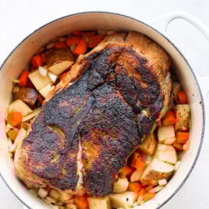 a baked pork roast with potatoes and carrots.