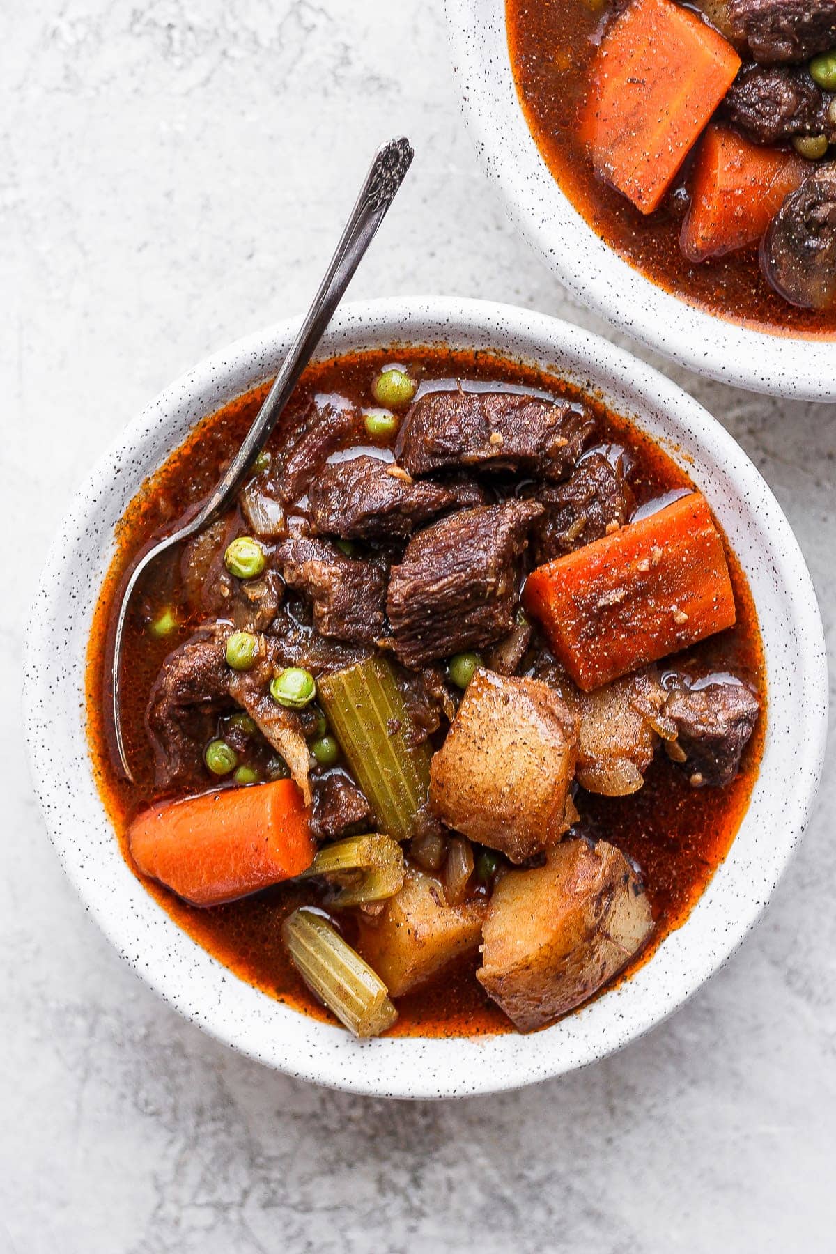 This Instant Pot Beef Stew is everything slow roasted stew is, but without the long cook time! Fall apart beef and tons of veggies, plus its ready to eat in under an hour. instant pot beef stew in a bowl with a spoon