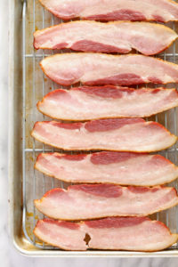 bacon-wrapped green beans on a baking sheet.