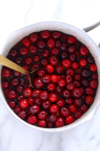 Unique cranberry sauce recipe served in a white bowl with a spoon.