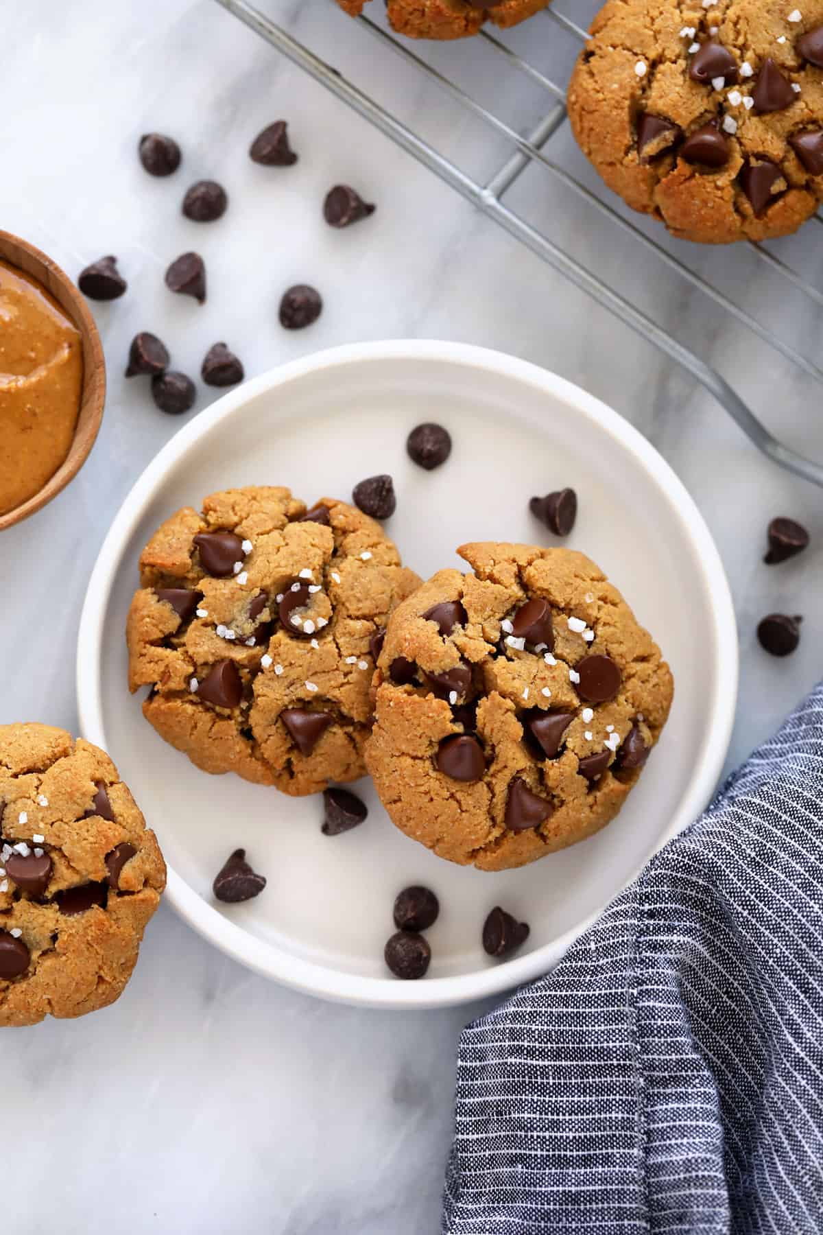 These Healthy Peanut Butter Cookies are flourless, chewy and oh so delicious with dark chocolate chips and a sprinkle of sea salt. healthy peanut butter cookies on a plate