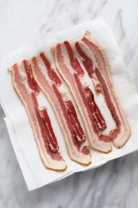 uncooked bacon on plate.