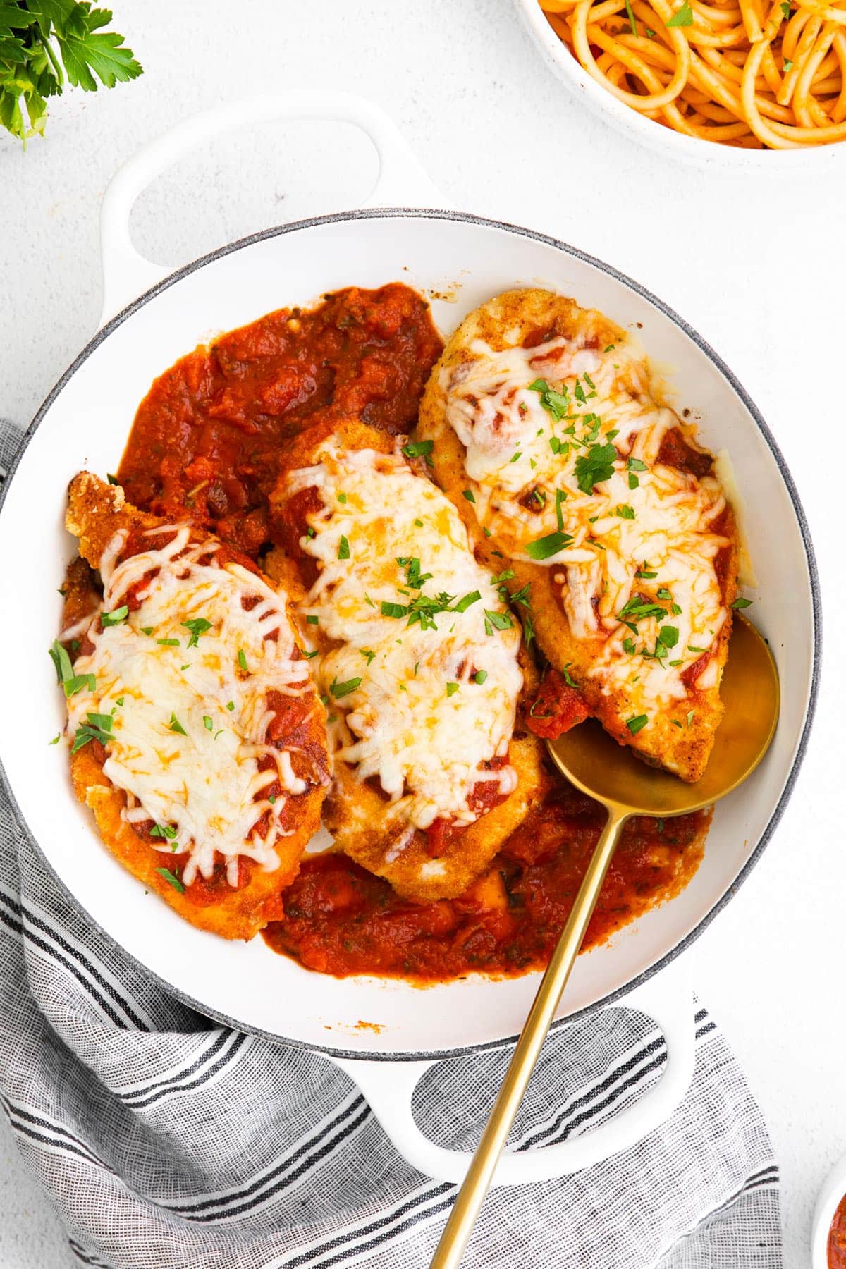Baked Chicken Parmesan is an easy chicken recipe to make. This oven baked chicken parmesan is first pan-fried and then finished off in the oven. chicken with marinara and cheese on top.