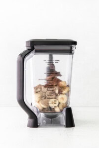 A blender filled with bananas and other ingredients.