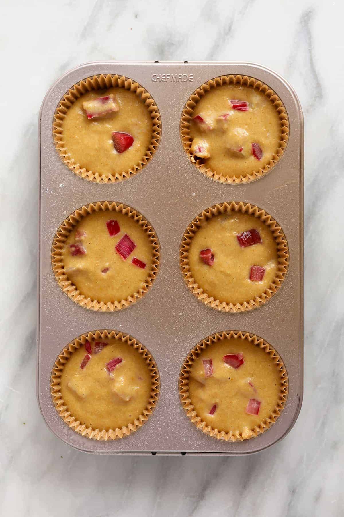 Rhubarb muffin batter in a muffin pan