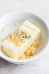 a white bowl with a piece of butter.