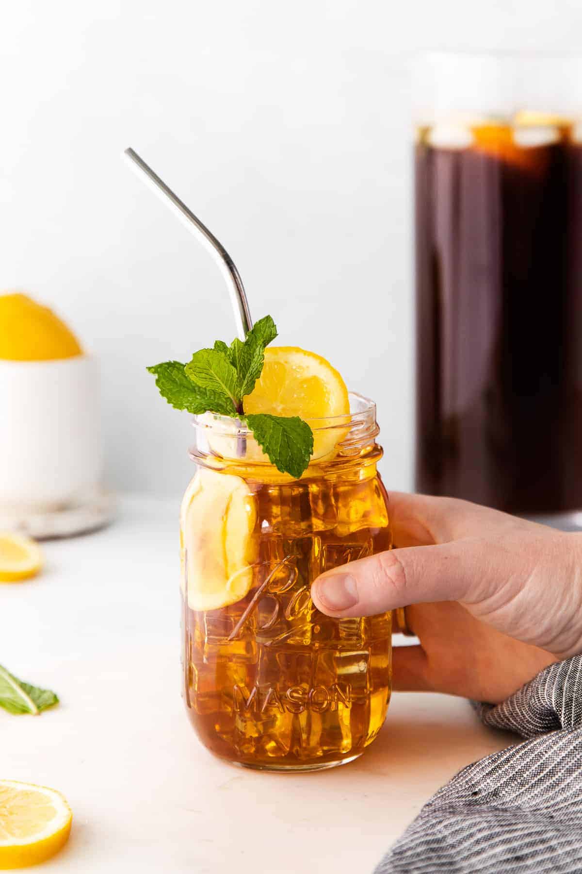 Cheers to the best homemade iced tea on the internet! This 6-ingredient iced tea recipe is as easy as it is delicious. Make a pitcher today! homemade iced tea in a mason jar garnished with mint and a lemon slice