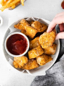 chicken nuggets in a bowl with ketchup.