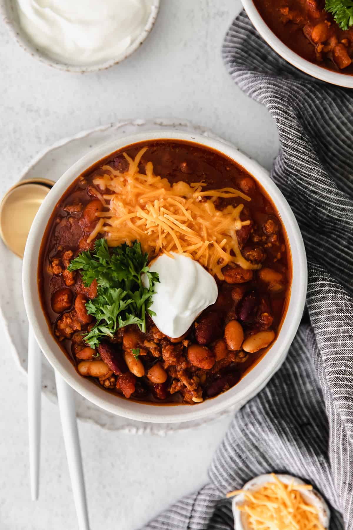 Whip up a batch of this delicious Instant Pot Chili in no time! This Instant Pot Chili recipe is made with ground beef, beans, tomato products, and homemade chili seasoning. instant pot chili topped with shredded cheese in a bowl.
