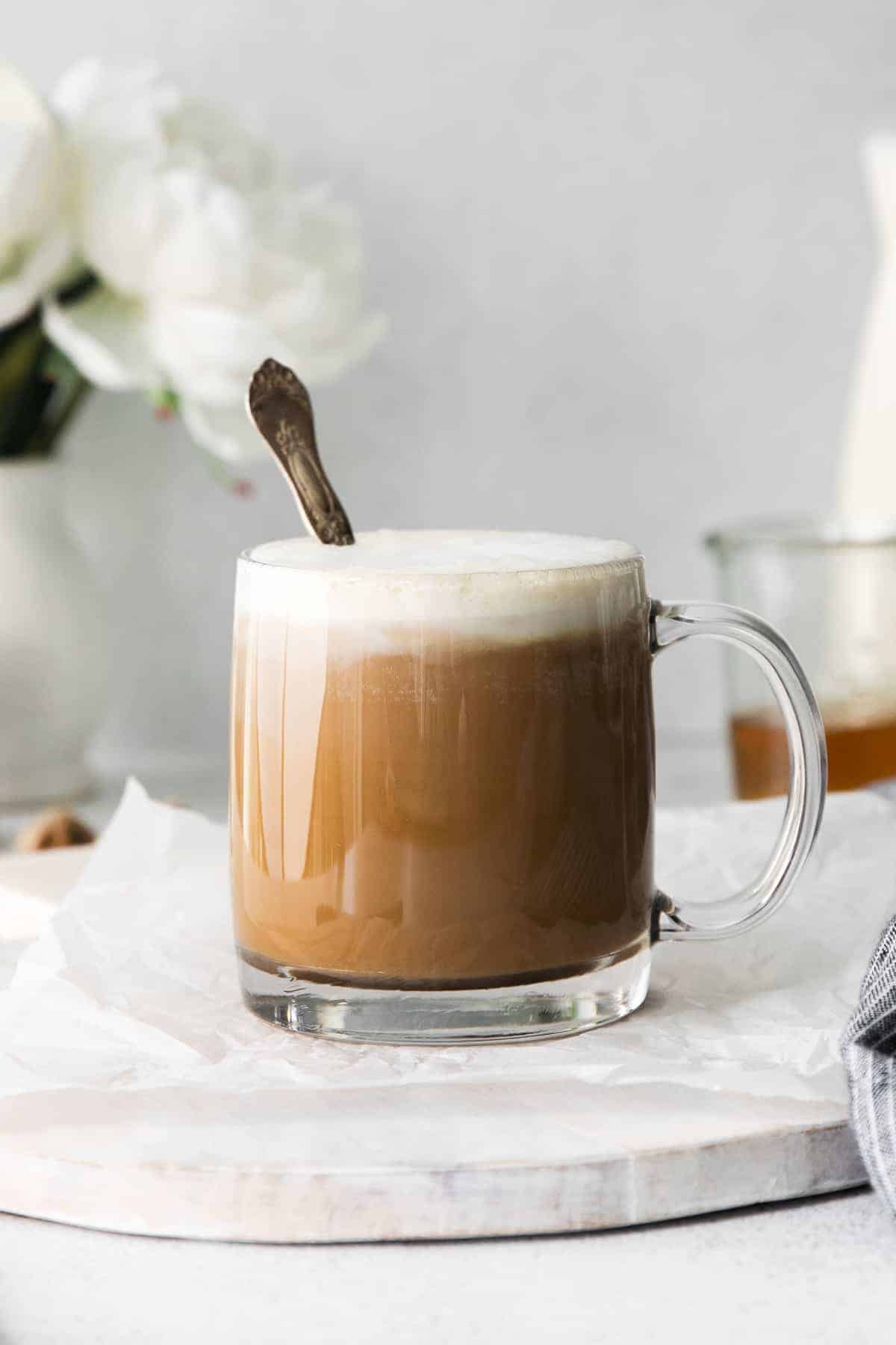 We'll show you how to make a miel in 4 easy steps in your own kitchen. Enjoy this coffee drink hot or cold. Cheers! miel latte in a coffee mug with a spoon